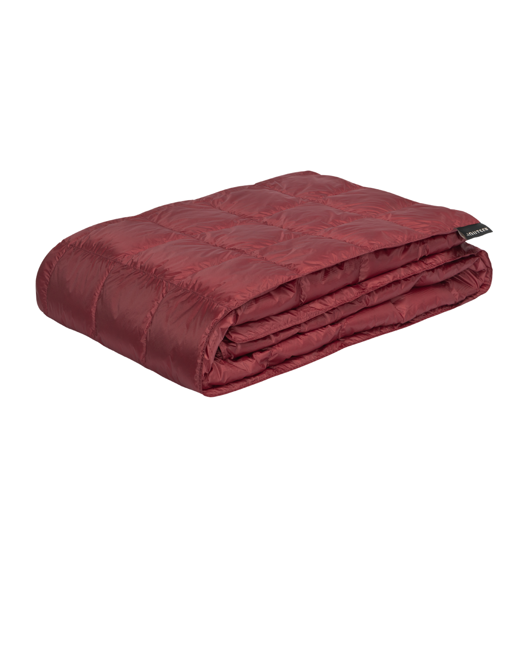 The red Kulkuri down blanket is neatly folded, and its surface is decorated with stitched square quilting patterns.