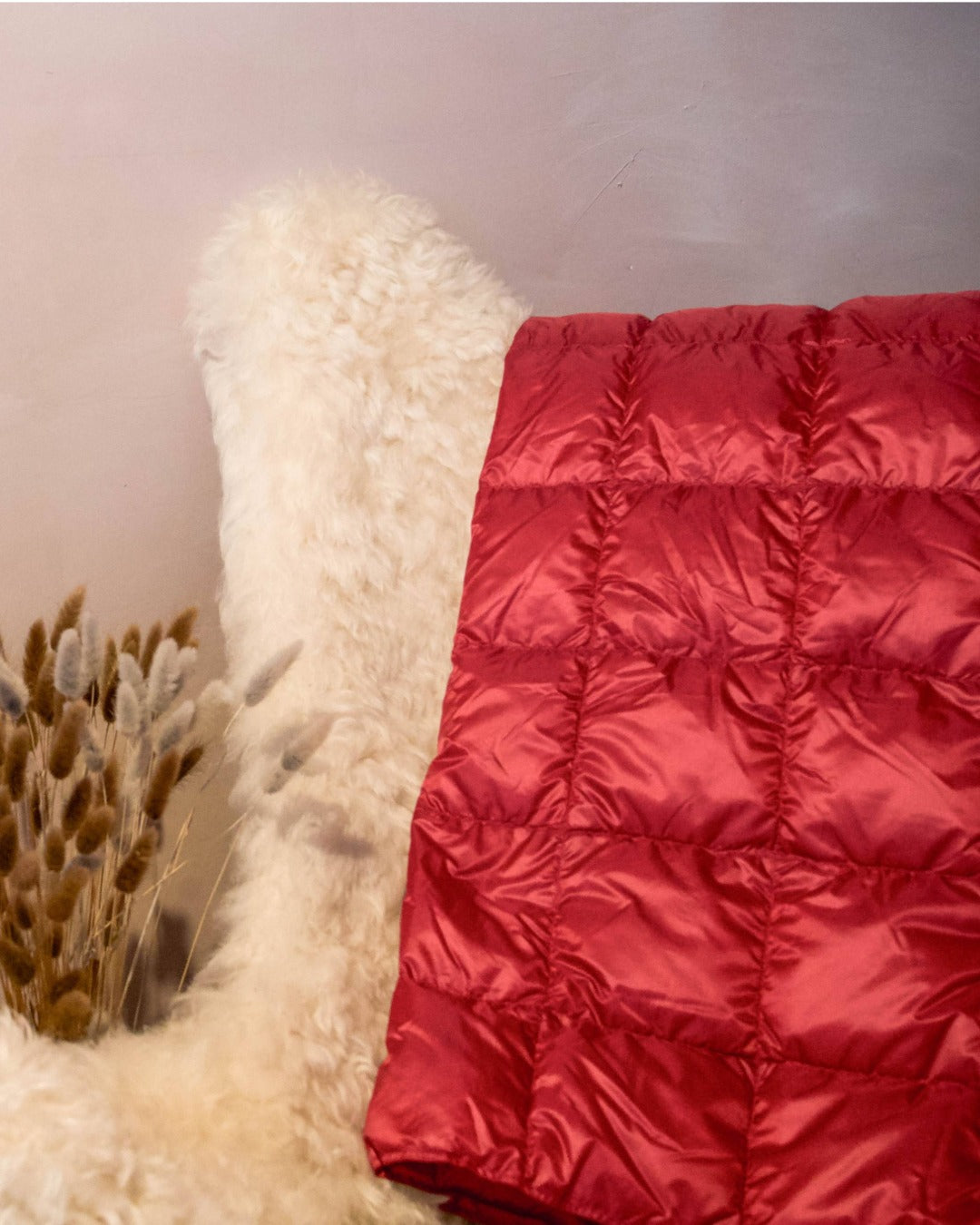 Red Kulkuri down blanket on a white surface with a neutral background