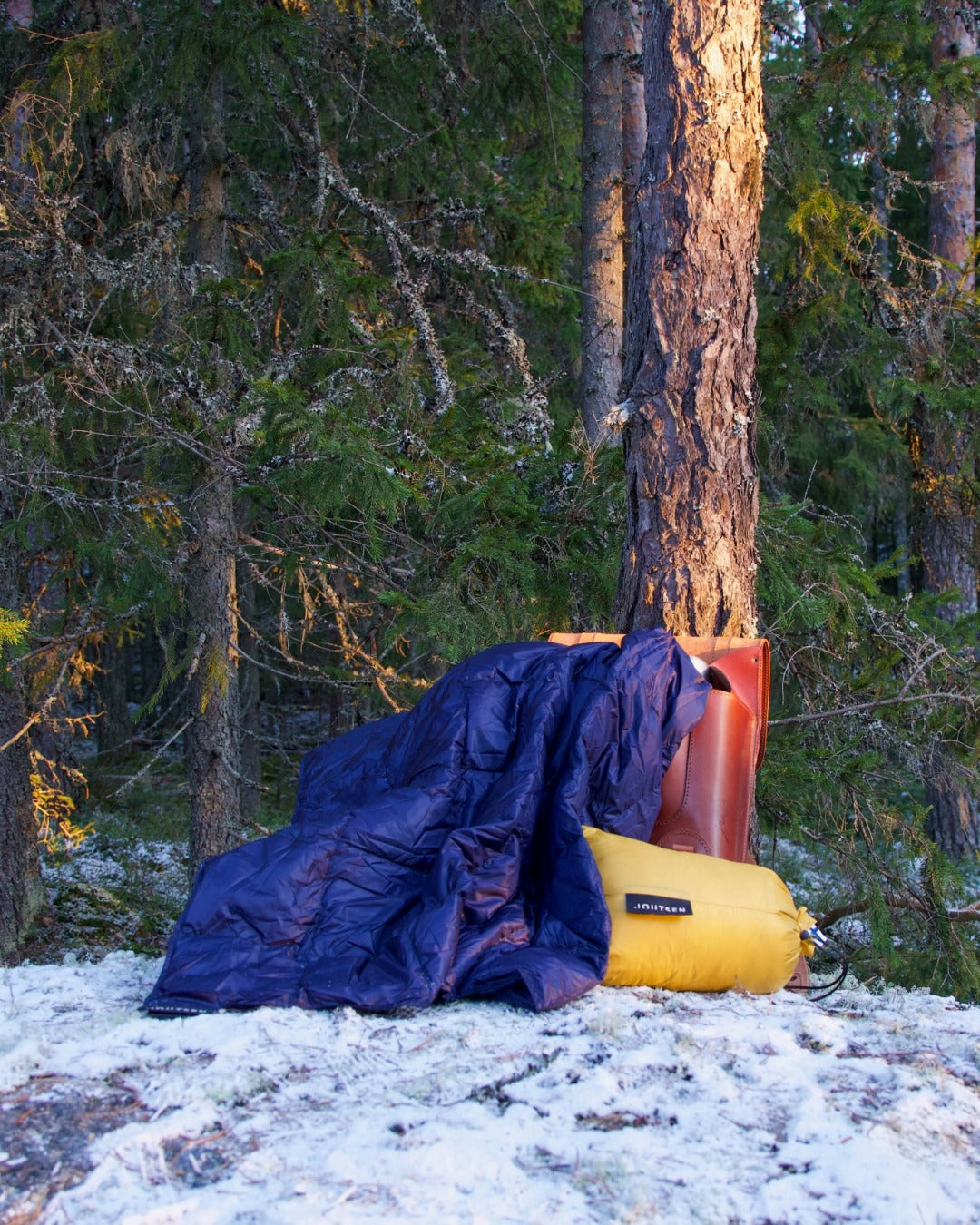 Dark blue Kulkuri down blanket in snowy forest