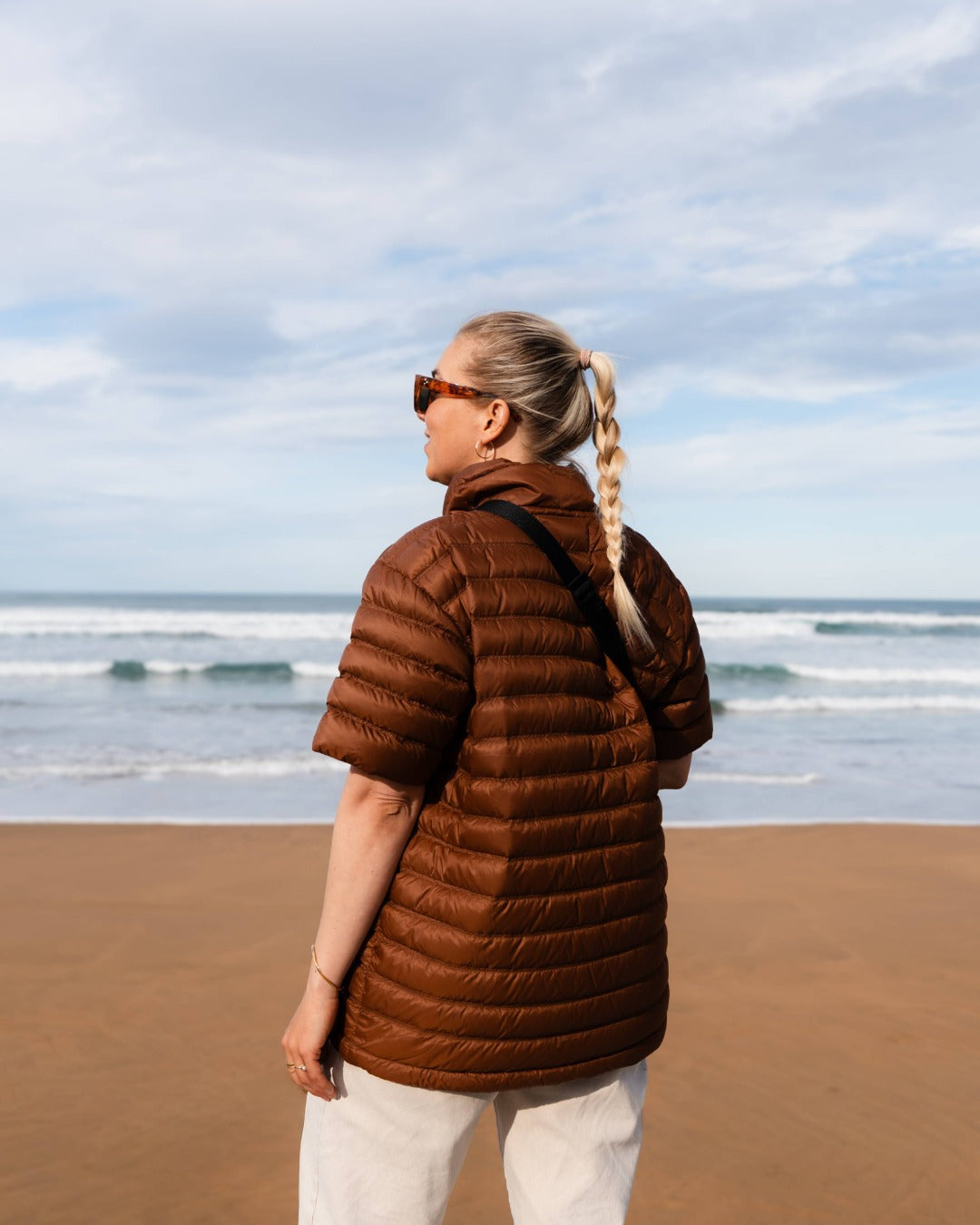 Person wearing a brown down shirt on a beach