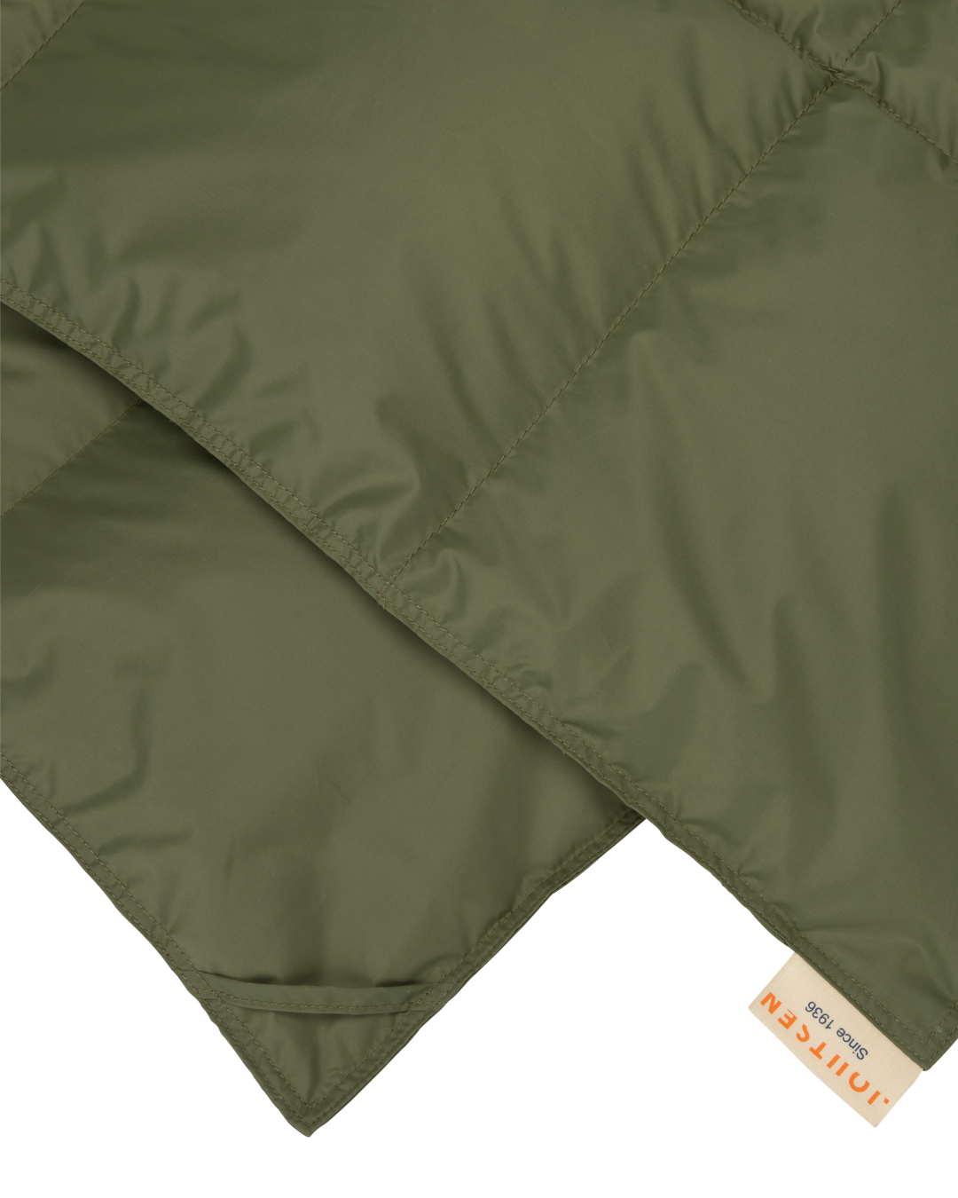 Two corners of Välly down blanket with a Joutsen-logo