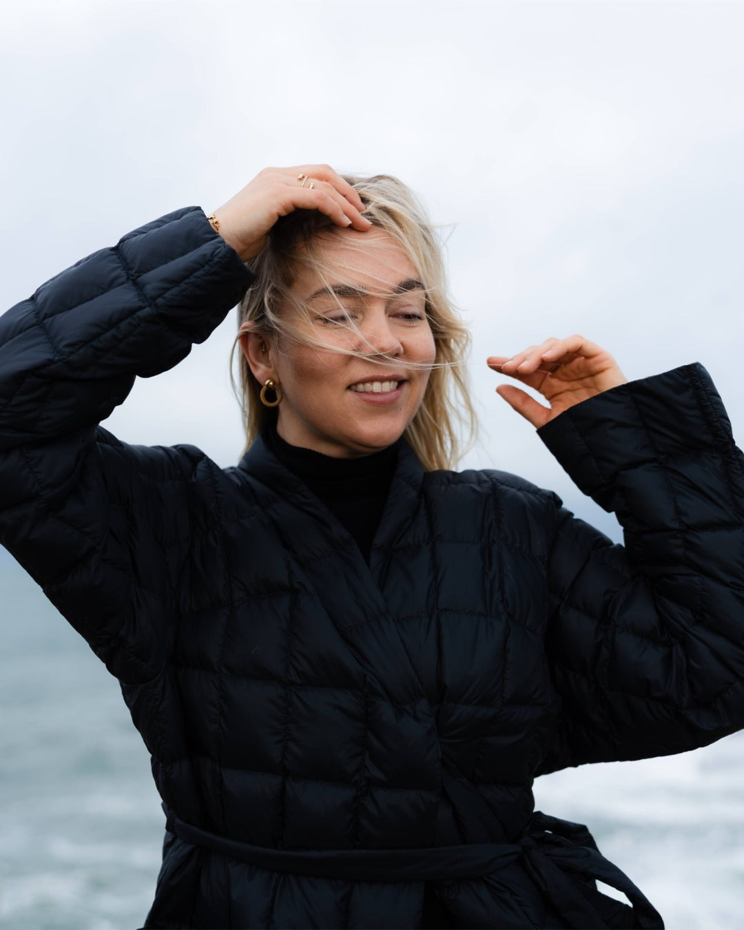 Person wearing a black down jacket with a blurred background
