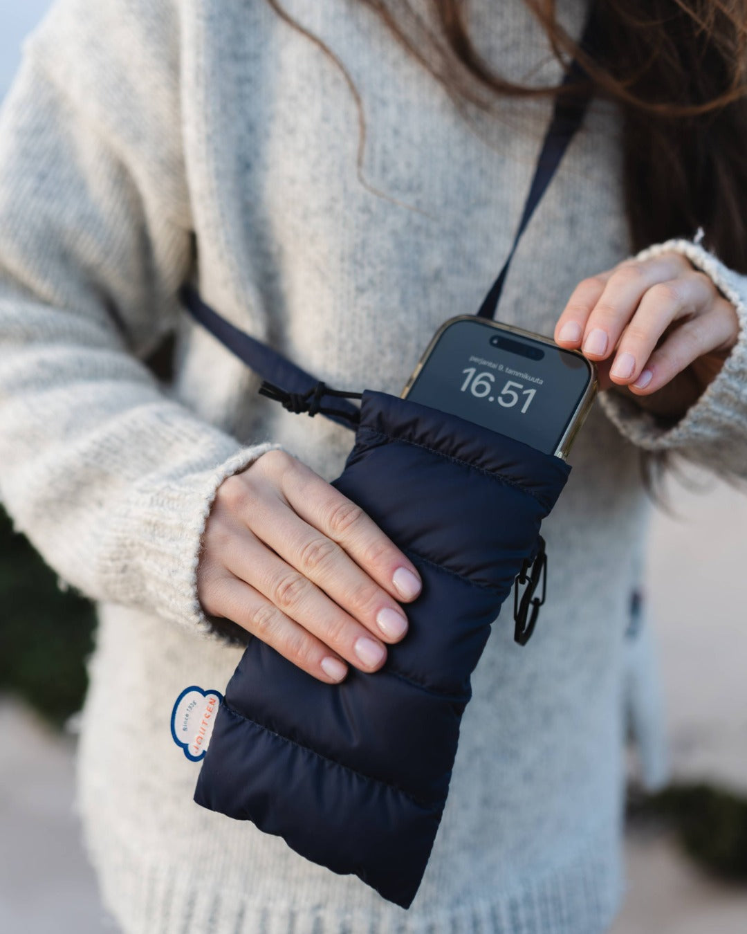 Person holding a black phone case with a digital display.