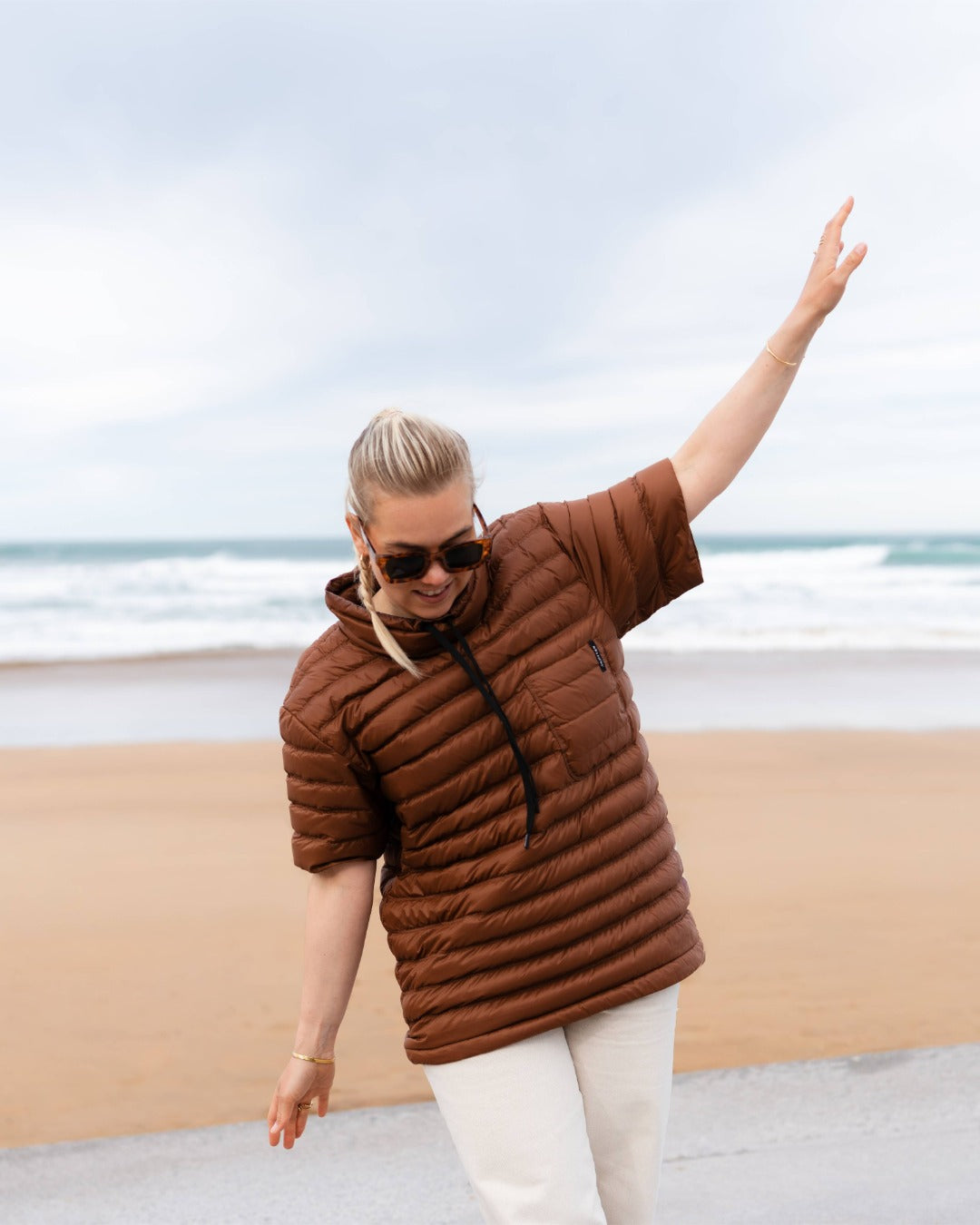 Person wearing a brown down shirt on a beach