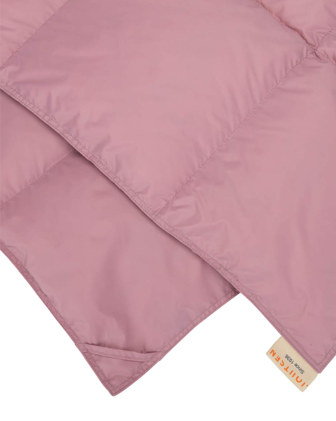 Two corners of Välly down blanket with a Joutsen logo