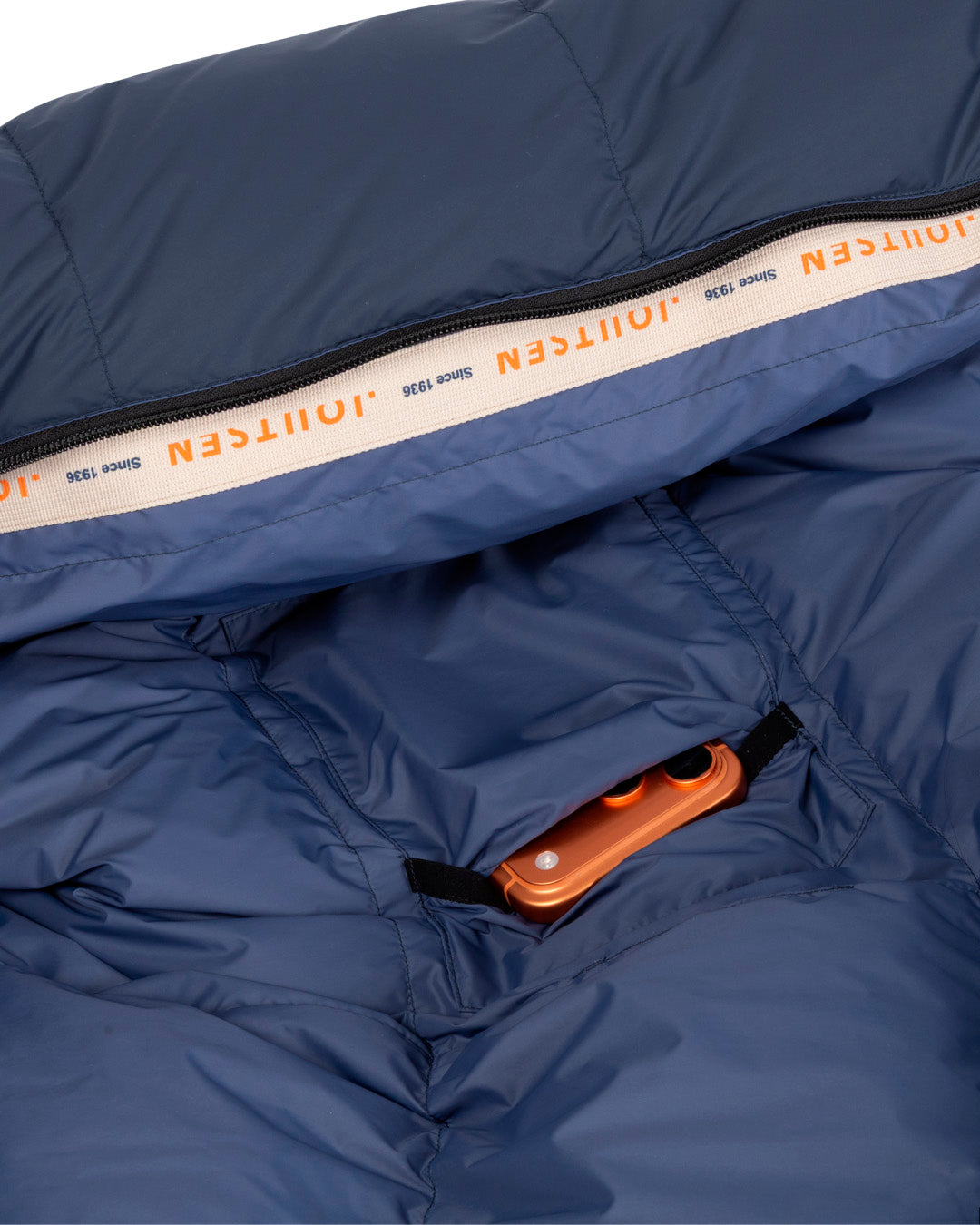 Close-up of a blue sleeping bag with a brand logo on the zipper.